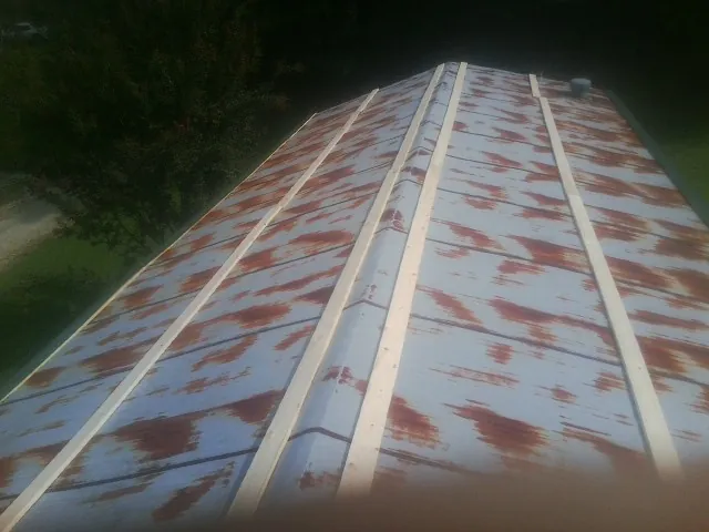 Rusted metal roof panels with new wood purlins before replacement — Storm Damage Roof Repair in Clanton by Roofing Brothers