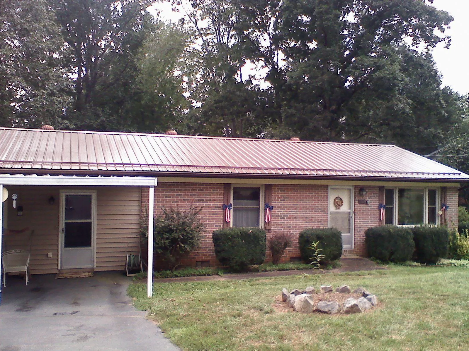 Bronze metal roof and carport on a brick ranch home — Roof Repair work by our crew in Clanton