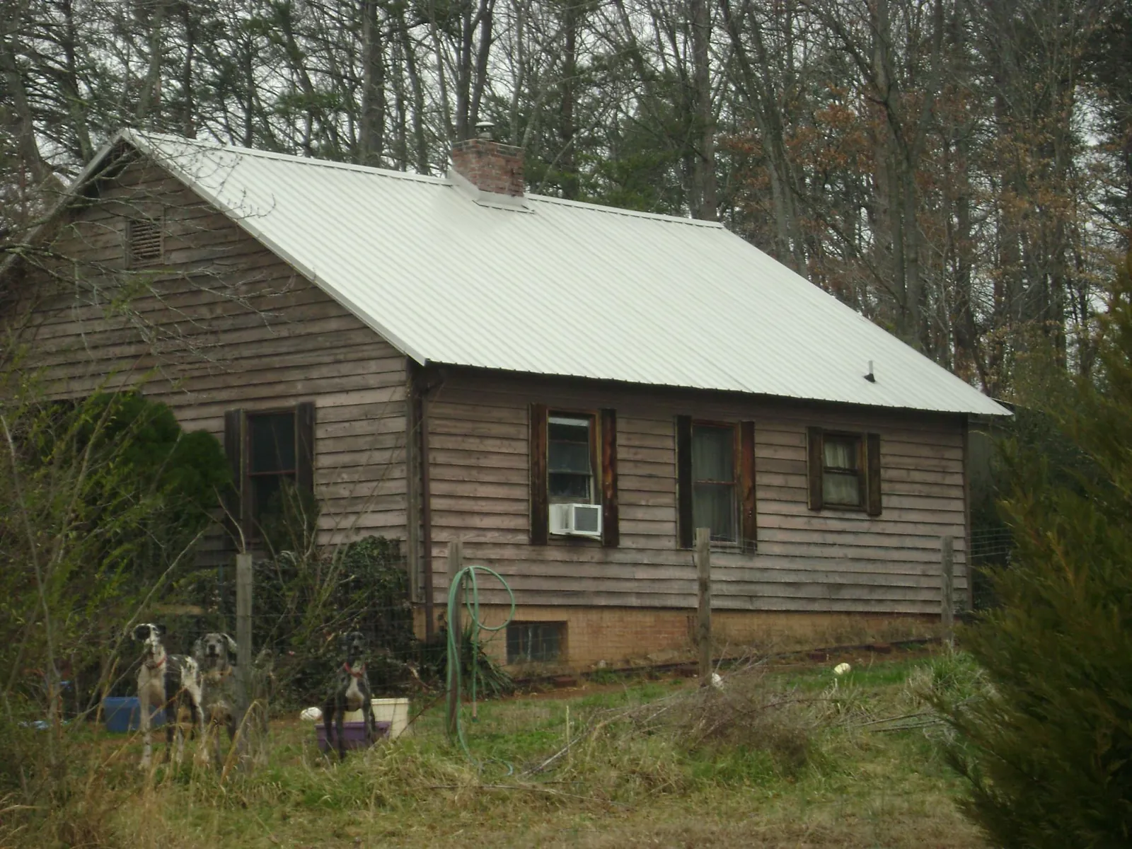 White metal roof on an old wood sided farmhouse, from a Asphalt Shingle Roof Repair job in Clanton